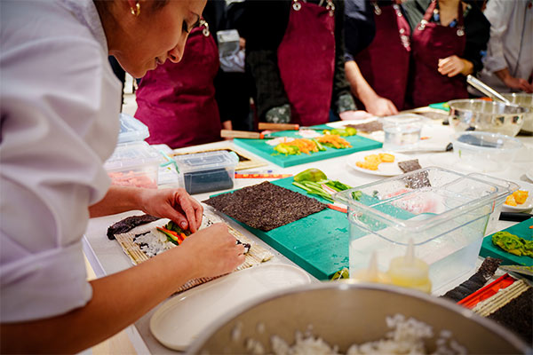 Image of person rolling sushi