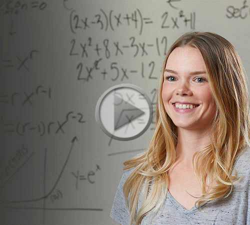 A female student posing in front of a dry erase board covered in equations. 