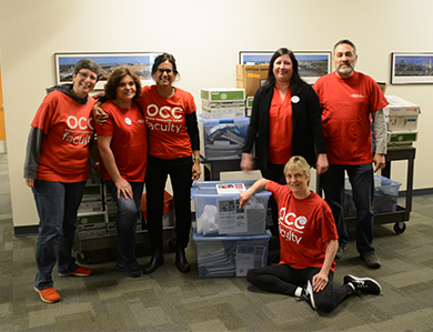 Oakland Community College Faculty surrounded by school supplies they donated to the Pontiac Education Association.