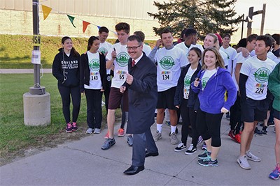 OCC Chancellor posing in front of OCC students before the start of the 5K.