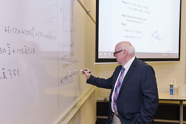 Pre-Engineering Program Directory, James O'Connor, writing out equations on a whiteboard