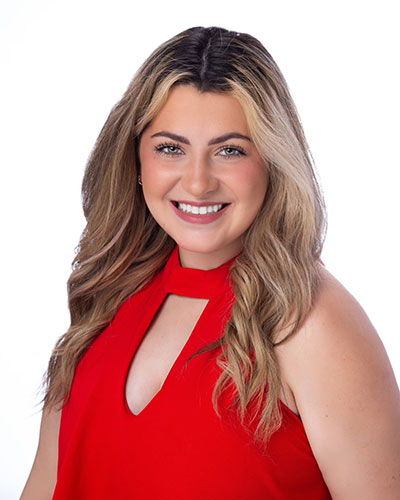 Marissa Carson posing for a professional headshot photo in front of a white backdrop. 